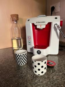 a coffee maker sitting on a counter with two cups at Fuori Arena in Casalecchio di Reno
