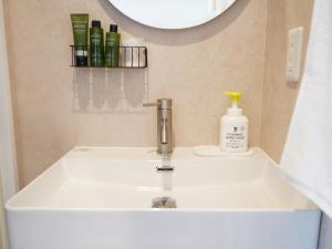 een wastafel in de badkamer met een kraan en een spiegel bij スタイリッシュハウス博多 in Fukuoka +57 foto's