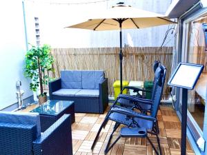 een patio met een tafel, een stoel en een parasol bij スタイリッシュハウス博多 in Fukuoka