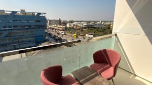 two chairs on a balcony with a cruise ship at Hotel Radhe in Junagadh