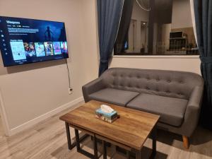 a living room with a couch and a table at BEHOME - Modern Guest Suite in Kumeu