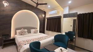 a bedroom with a bed and chairs in it at Hotel Radhe in Junagadh
