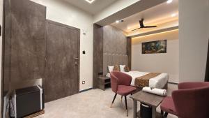 a hotel room with a bed and a tv and a table at Hotel Radhe in Junagadh