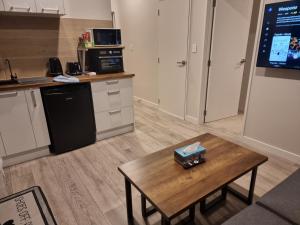 a living room with a table and a kitchen at BEHOME - Modern Guest Suite in Kumeu