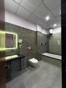 a bathroom with a tub and a toilet and a sink at Aijasvan Hotel in Sawāi Mādhopur +57 photos