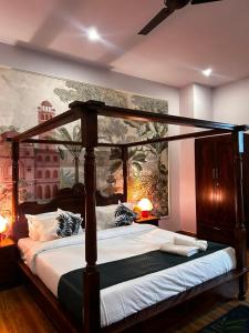 a bedroom with a canopy bed with a painting on the wall at Aijasvan Resort in Sawāi Mādhopur +58 photos