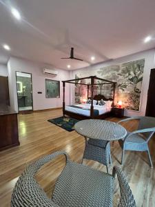 a bedroom with a bed and a table and chairs at Aijasvan Resort in Sawāi Mādhopur