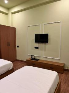 a hotel room with two beds and a flat screen tv at Aijasvan Resort in Sawāi Mādhopur