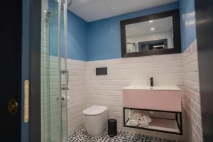 une salle de bains avec toilettes, lavabo et miroir dans l'établissement RUWTS Valletta Central Maisonette, à La Valette