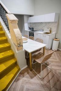 - une cuisine et une salle à manger avec une table et des escaliers dans l'établissement RUWTS Valletta Central Maisonette, à La Valette