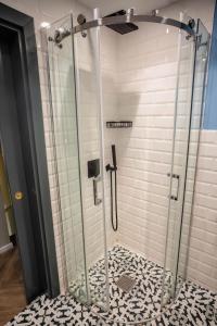 - une douche avec une porte en verre sur du carrelage dans l'établissement RUWTS Valletta Central Maisonette, à La Valette