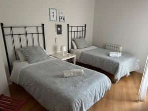 Un dormitorio con dos camas y una mesa con una silla. en Los Seis Caños, en Madrigal de la Vera