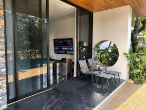 a glass extension of a house with a table and chairs at Khanom Station 549 in Ban Na Dan