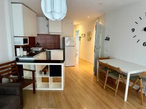 Una cocina y una sala de estar con mesa y sillas. en Los Seis Caños, en Madrigal de la Vera