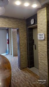 una habitación con un reloj en la pared y una puerta en Kahraman Amman Hotel, en Amán