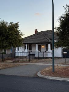 een wit huis met een hek ervoor bij Perth Boutique Heritage in Perth +4 foto's