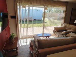 a living room with a couch and a sliding glass door at Departamento Los Sauces in Macachín