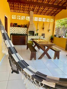 un'amaca in una stanza con un tavolo e una stufa di Casa da Helô a Icapuí