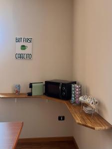 a microwave sitting on top of a wooden shelf at Da Zia Mery in Edolo