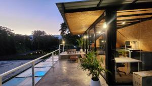 a house with a balcony with a view of a pool at Seven 50s in Pai