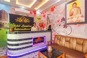 a living room with a couch and a wall with a sign at FabHotel Lumbini International - Nr Sarnath Museum in Varanasi