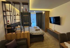 a living room with a bed and a television at B8 Residence hill in Kopaonik