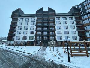 a large building in the snow in front of a street at B8 Residence hill in Kopaonik