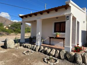 El Descanso Cafayate في كفايات: منزل أبيض صغير أمامه مسرح