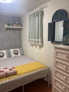 a small bedroom with a bed and a dresser at Cueva Colorin Alloza. in Alloza