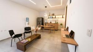 a living room with tables and chairs and a kitchen at Hotel El Cedro Exclusive in Florencia