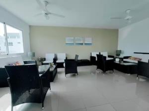 Departamento en Santo Domingo في سانتو دومينغو: غرفة طعام مع كراسي سوداء وطاولات