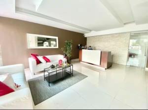 Departamento en Santo Domingo في سانتو دومينغو: غرفة معيشة مع أريكة بيضاء وتلفزيون