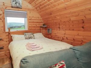 a bedroom with a bed in a log cabin at Willow in Ulverston