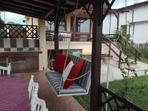 un dondolo con cuscini rossi su una casa di Vila Panorama a Izgrev Altre 22 foto