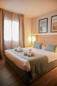 翁弗勒尔LE M HOTEL & SPA HONFLEUR的一间卧室，有一张大床，上面有两个枕头