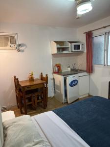 a room with a bed and a kitchen with a table at HColon in Colón