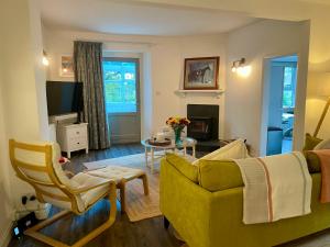 a living room with a yellow couch and a table at Dartmoor Cottage in Bovey Tracey