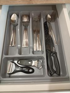 a tray filled with utensils in a drawer at Apartman Slađa in Novi Sad