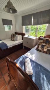 a bedroom with two beds and a chair and a window at The Ark Holiday Home in Stanford +10 photos