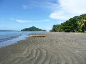 un barco amarillo sentado en una playa junto al océano en Zaru Hotel, en Gizo