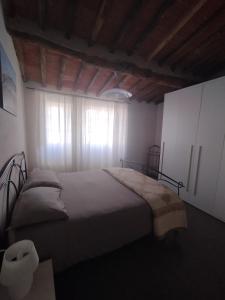 a bedroom with a large bed and a window at Denisoph Apartment in Lucca