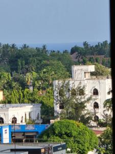 a building on a hill with trees in the background at Zuri Homes 6 B in Mombasa