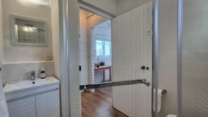 a white bathroom with a sink and a mirror at Bramber cottage Stay a while in Stanford