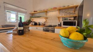 a kitchen with a bowl of lemons and a bottle of wine at Bramber cottage Stay a while in Stanford