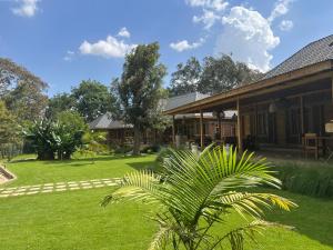 a house with a palm tree in front of a yard at Our Stay Mlima in Arusha