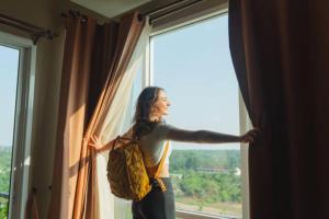 a woman is looking out of a window at Chitwan Paradise Hotel in Sauraha +87 photos