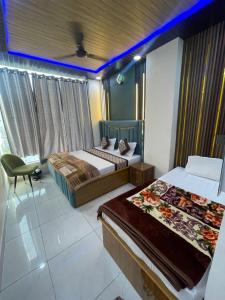 a hotel room with two beds and a chair at Hotel Himalayan Residency in Jāmb