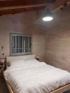 Ένα ή περισσότερα κρεβάτια σε δωμάτιο στο הבקתה