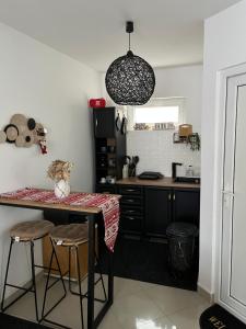 a kitchen with a table and two stools in it at Apartman Centar Strpce in Štrpce +20 photos