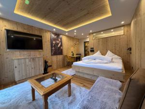 Un dormitorio con una cama, un televisor y una mesa. en ALPtyrol-Sennerei, en Sankt Anton am Arlberg
